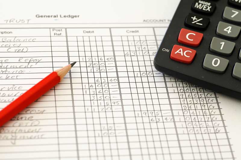 photo of a general ledger, pencil and calculator